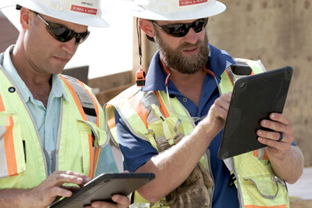 construction workers looking at drawings on an iPad